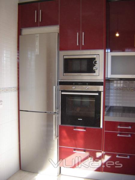 Cocina en formica brillo combinando los colores granate y negro con los cuatro cantos inox. Encimera en Silestone ...