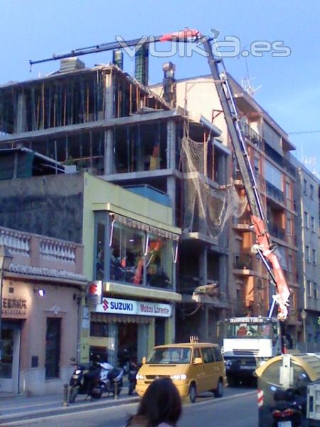 GRUA ELEVANDO MATERIALES EN OBRA Y HORMIGONANDO 