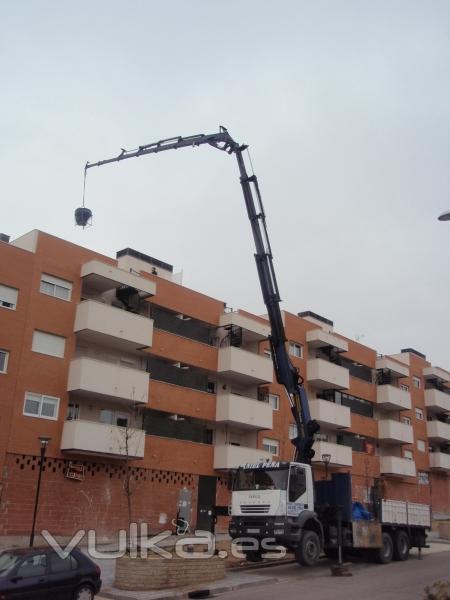 Camion-grua subiendo materiales a cubierta.