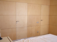 Panelado de pared con tablero marino de abedul puertas enrasadas en el mismo plano