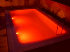 Iluminacion con luces de leds en piscina desbordante con gresite blanco perla