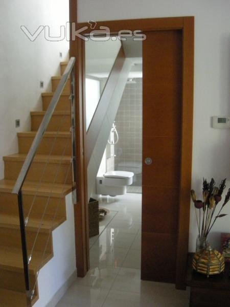 Puerta acceso baño con lateral a escalera transparente