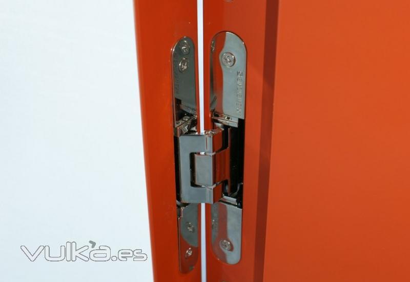 Sistema de bisagras completamente oculto y integrado en el cerco de aluminio de una puerta de paso. 