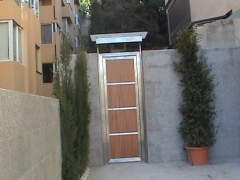 Puerta exterior en acero inoxidable combinada con madera marquesina incluida