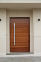Puerta de 120 x 220 cm. en madera de iroko y tirado r de acero inox.