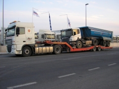 Cabeza tractora y banera cargados en un semi-remolque porta-vehiculos
