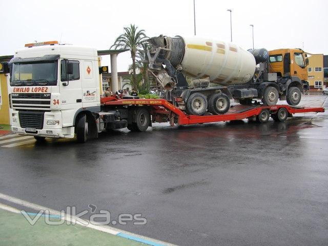 Hormigonera cargada en un semi-remolque porta-vehículos.