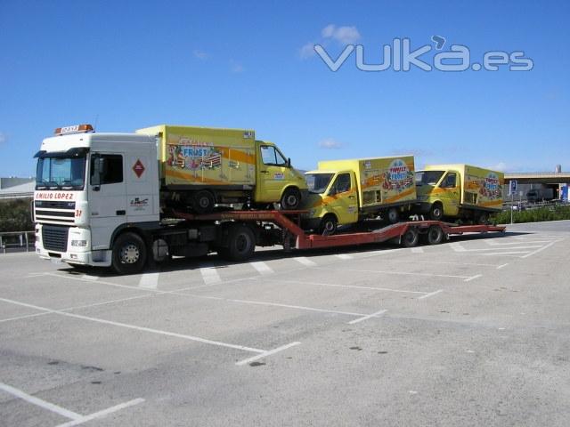 Múltiples furgonetas cargadas en un semi-remolque porta-vehículos.