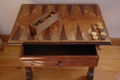 Mesa tallada y marquetada con el juego del backgammon. barnizada a muequilla.