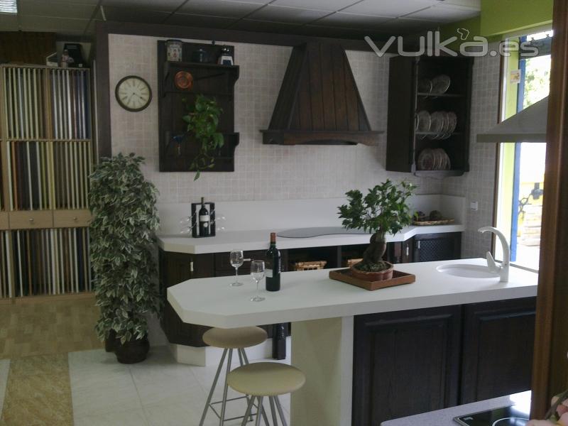 Cocina de isla en madera roble wengue con encimera blanca.