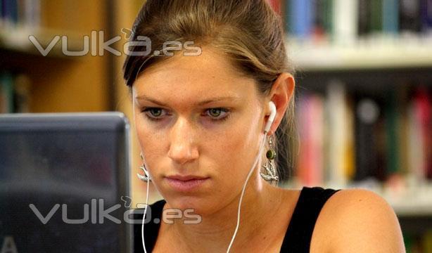 Una estudiante trabajando con su portatil en la biblioteca