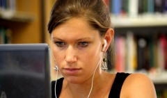 Una estudiante trabajando con su portatil en la biblioteca