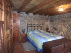 Dormitorio con paredes de piedra